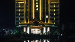 Un hotel con una entrada destacada y su reflejo en el agua.