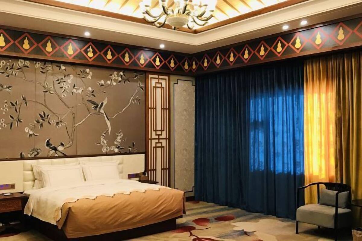 Ein Schlafzimmer mit einem Bett, einem Sessel und einer Zierwandverkleidung.