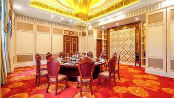 A dining room with a round table, chairs, and a patterned carpet.