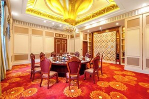 A dining room with a round table, chairs, and a patterned carpet. - Menluo Wa Jing Luxury Grand Hotel(Hulu Town Wa Tribe Branch) (Cangyuan)
