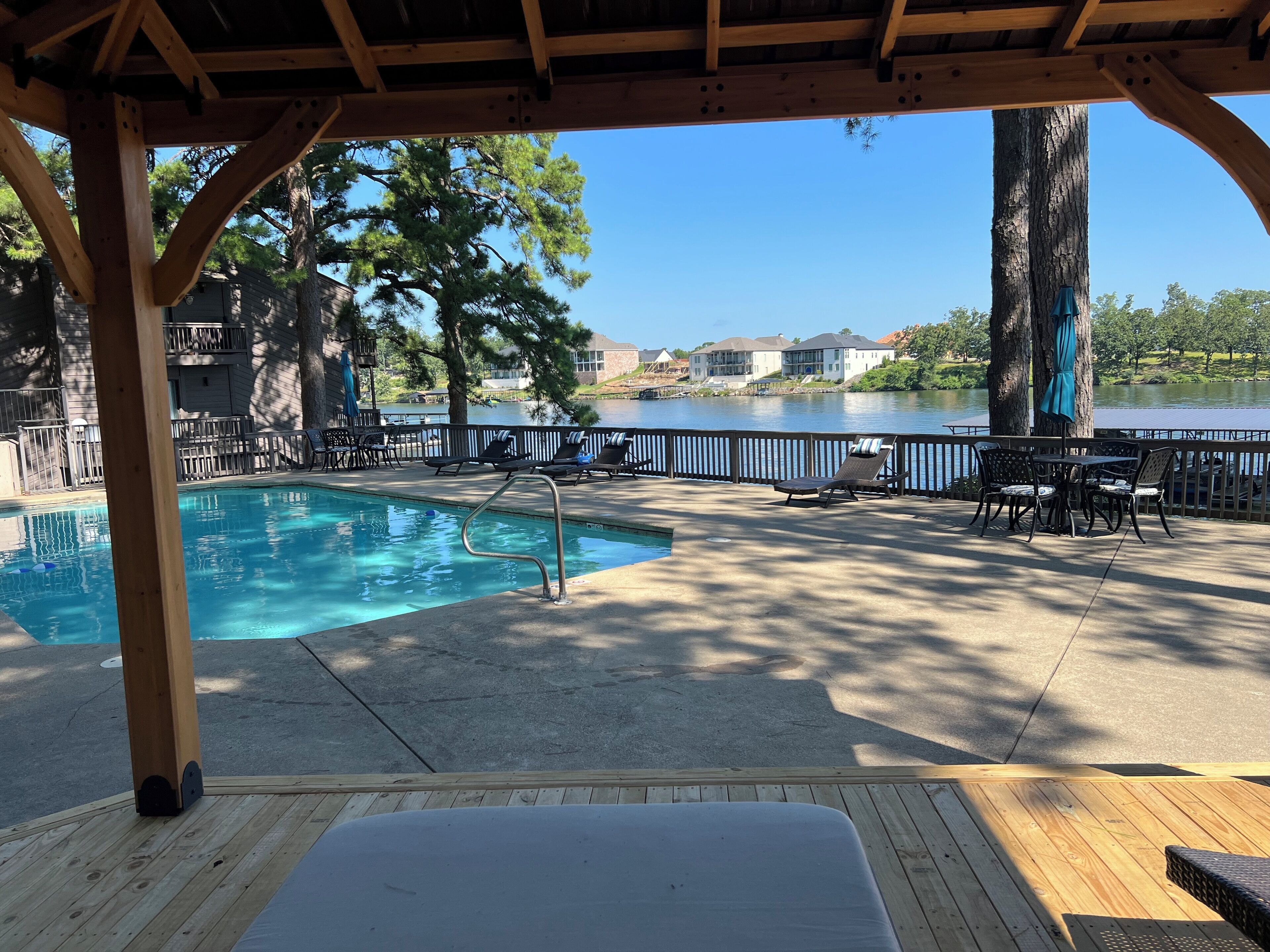 Un espace piscine avec des chaises longues et une vue sur un lac.