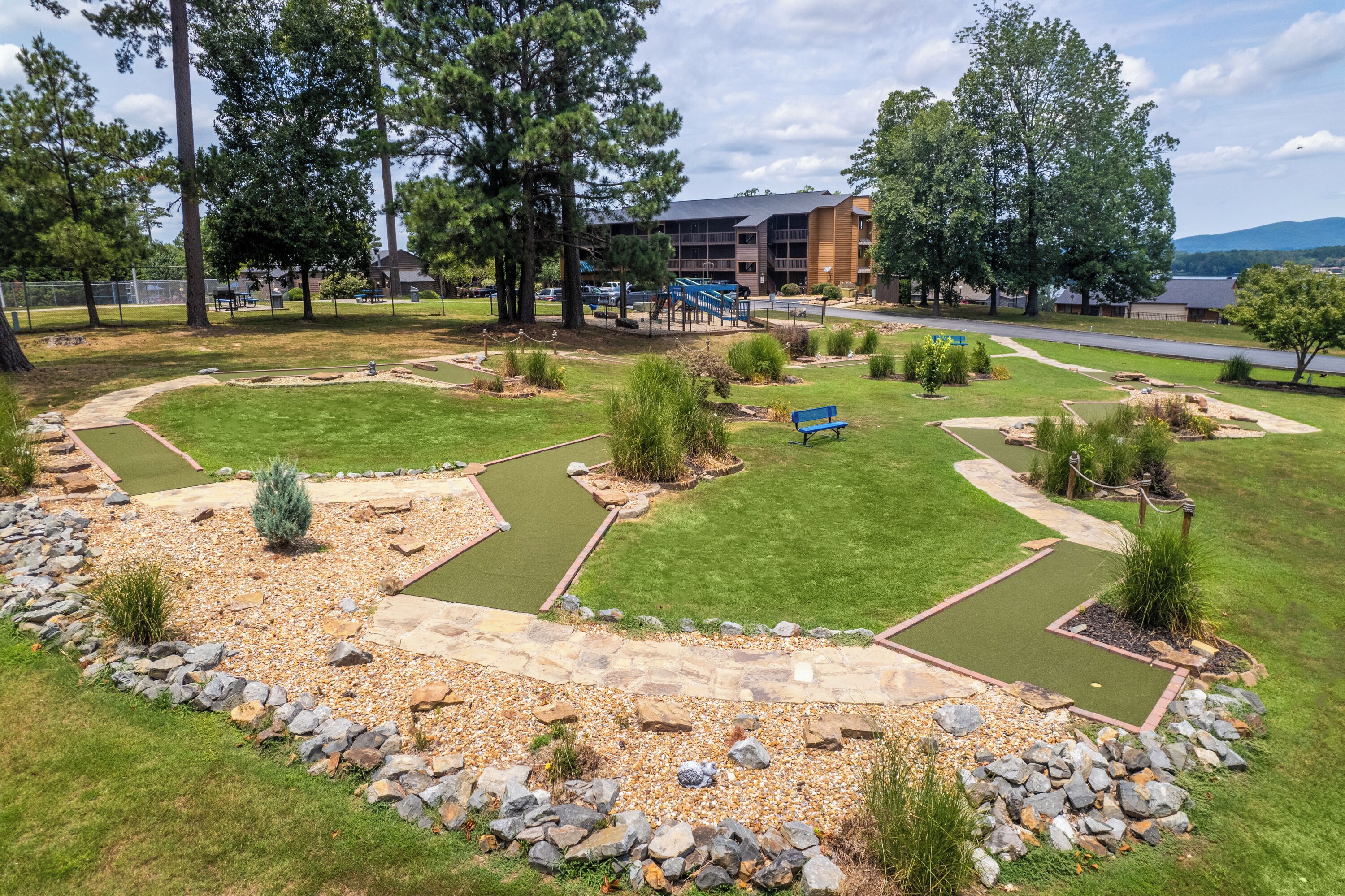 A well-maintained outdoor area with a putting green, a walking path, and a seating area.