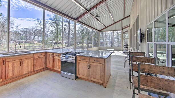 A spacious kitchen with wooden cabinets, a large island, and a view of the outdoors.