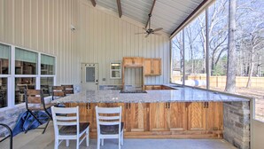 A spacious kitchen with a large island, wooden cabinets, and a view of the outdoors.