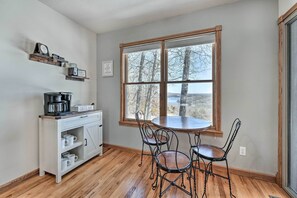 Enjoy meals at the central table in this well-organized kitchen with a coffee station and window view.