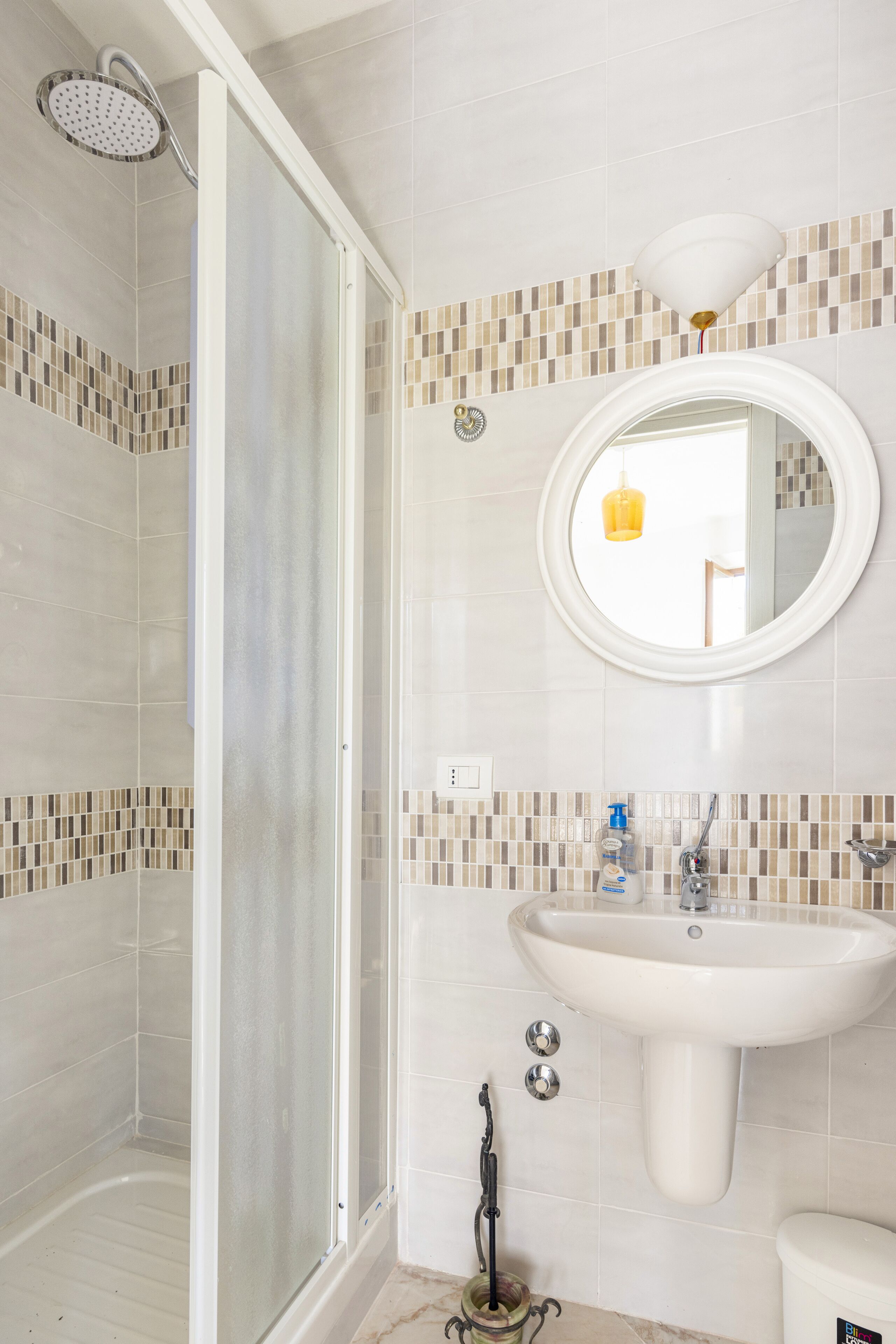 Une salle de bain avec une douche, un lavabo et un miroir.