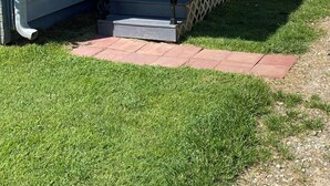 A house with a front porch, a small set of stairs, and decorative stars on the wall. - Welcome to our Wichita Home - Easy Close Access to Turnpike South Side (Wichita)