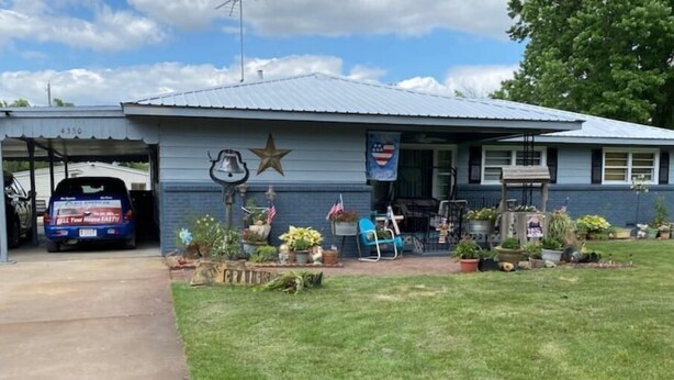 A single-story building with a garage, a star decoration, and a flag. - Welcome to our Wichita Home - Easy Close Access to Turnpike South Side (Wichita)