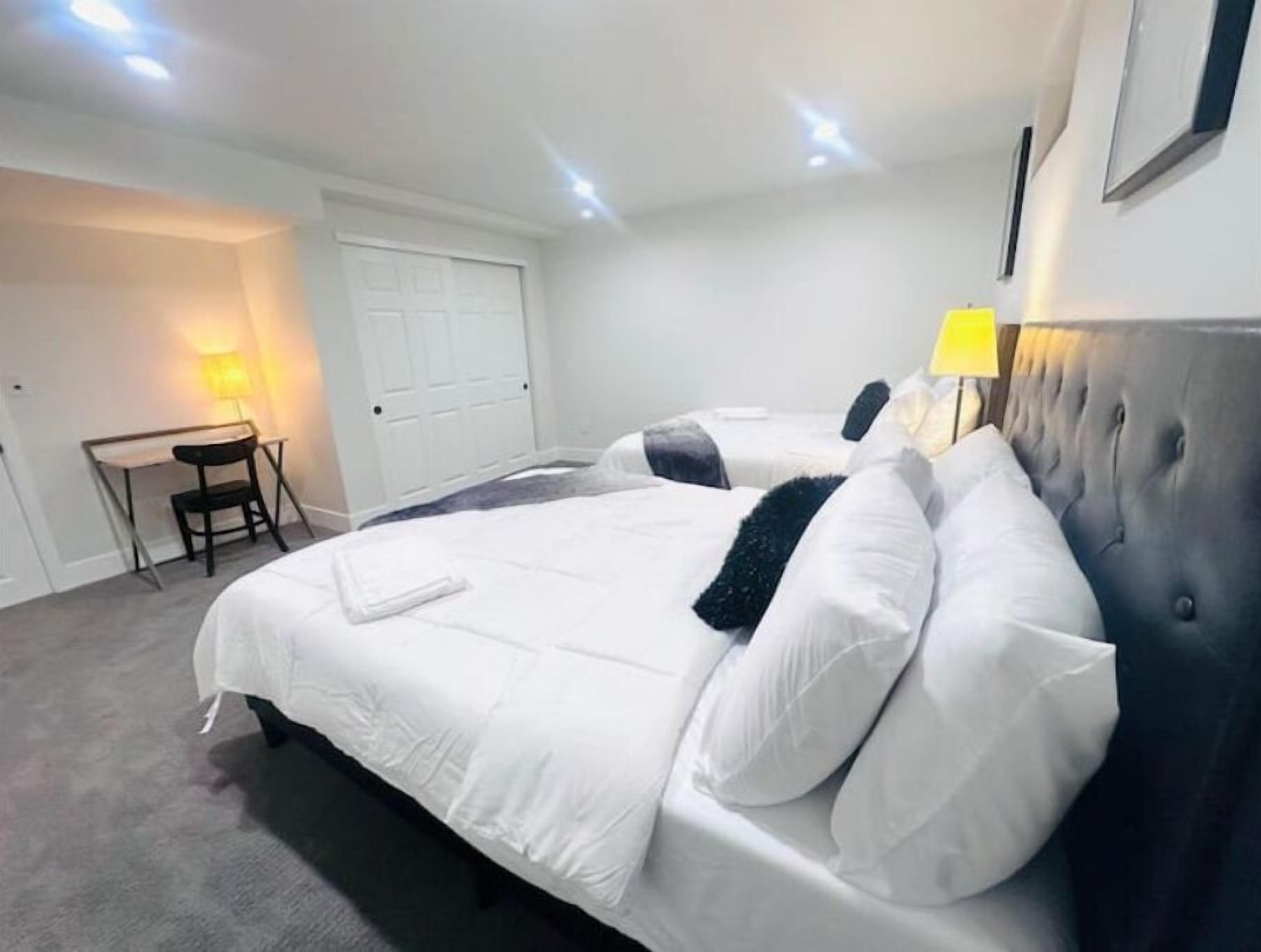 Habitación de hotel con dos camas, un escritorio y una silla.