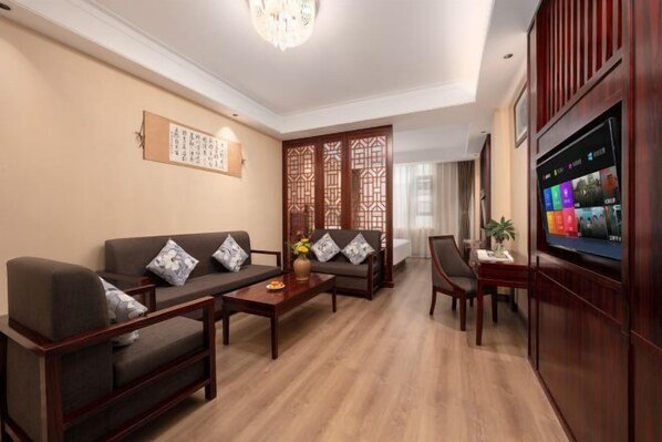 A living room with a sofa set, a coffee table, a TV, and a decorative screen. - Fall In Love With Nujiang Grand Canyon Hotel (Lushui)