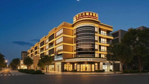 A multi-story hotel with a prominent curved facade and a crescent moon in the sky. - Fall In Love With Nujiang Grand Canyon Hotel (Lushui)