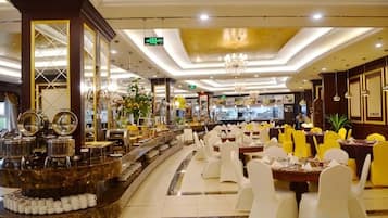 A hotel lobby with a curved reception desk, white chairs, and a chandelier.