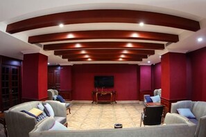 A room with a curved ceiling, red walls, and a flat-screen TV mounted on the wall. - Aohua International Hot Spring Hotel (Linyi)