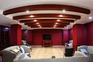 A room with a curved ceiling, red walls, and a flat-screen TV mounted on the wall.