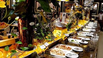 A buffet with various food items and a decorative tree centerpiece.