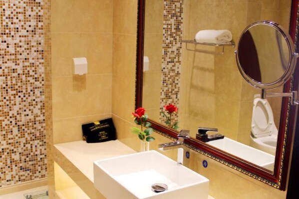A bathroom with a white sink, a mirror, and a toilet. - Aohua International Hot Spring Hotel (Linyi)