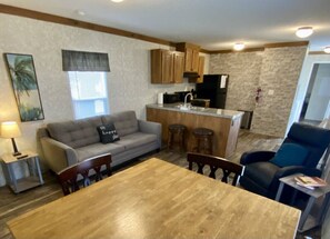 A compact living space with a kitchenette, a dining area, a sofa, and a chair. - Rainbow River Bungalow R (Dunnellon)