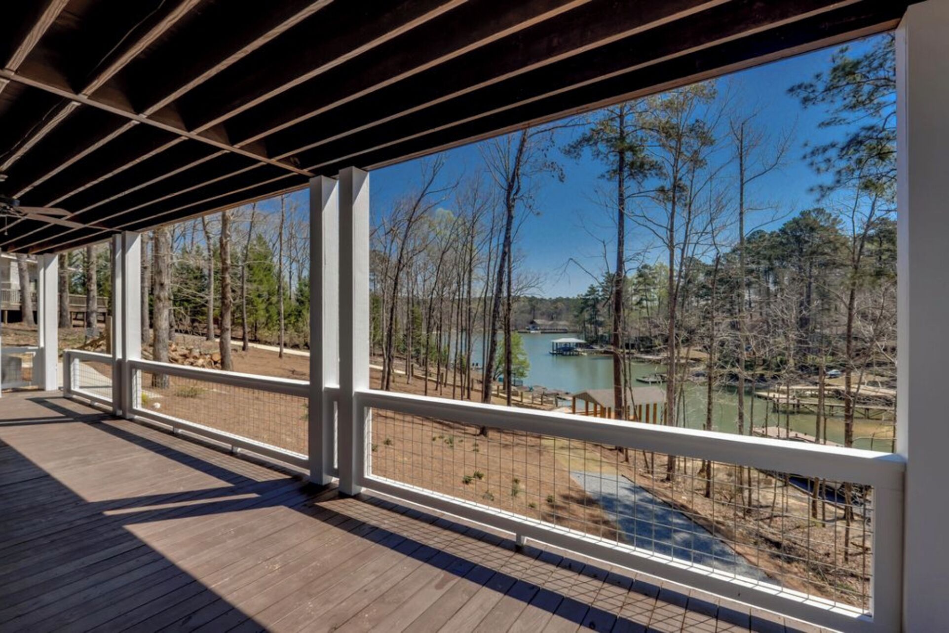 A covered outdoor area with a view of a lake and trees.