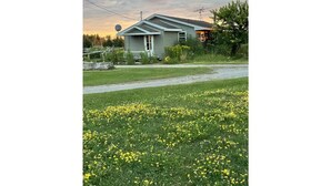 A house with a sloped roof, a front porch, and a satellite dish. - Comfy Farmstay. Les Cheneaux Islands, Near to Mackinac Is., fresh eggs. Trails. (Hessel)