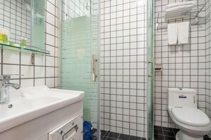 A bathroom with a glass shower enclosure, a white sink, and a toilet. - Hello Light Hotel (Guangzhou Yantang Metro Station) (Guangzhou)