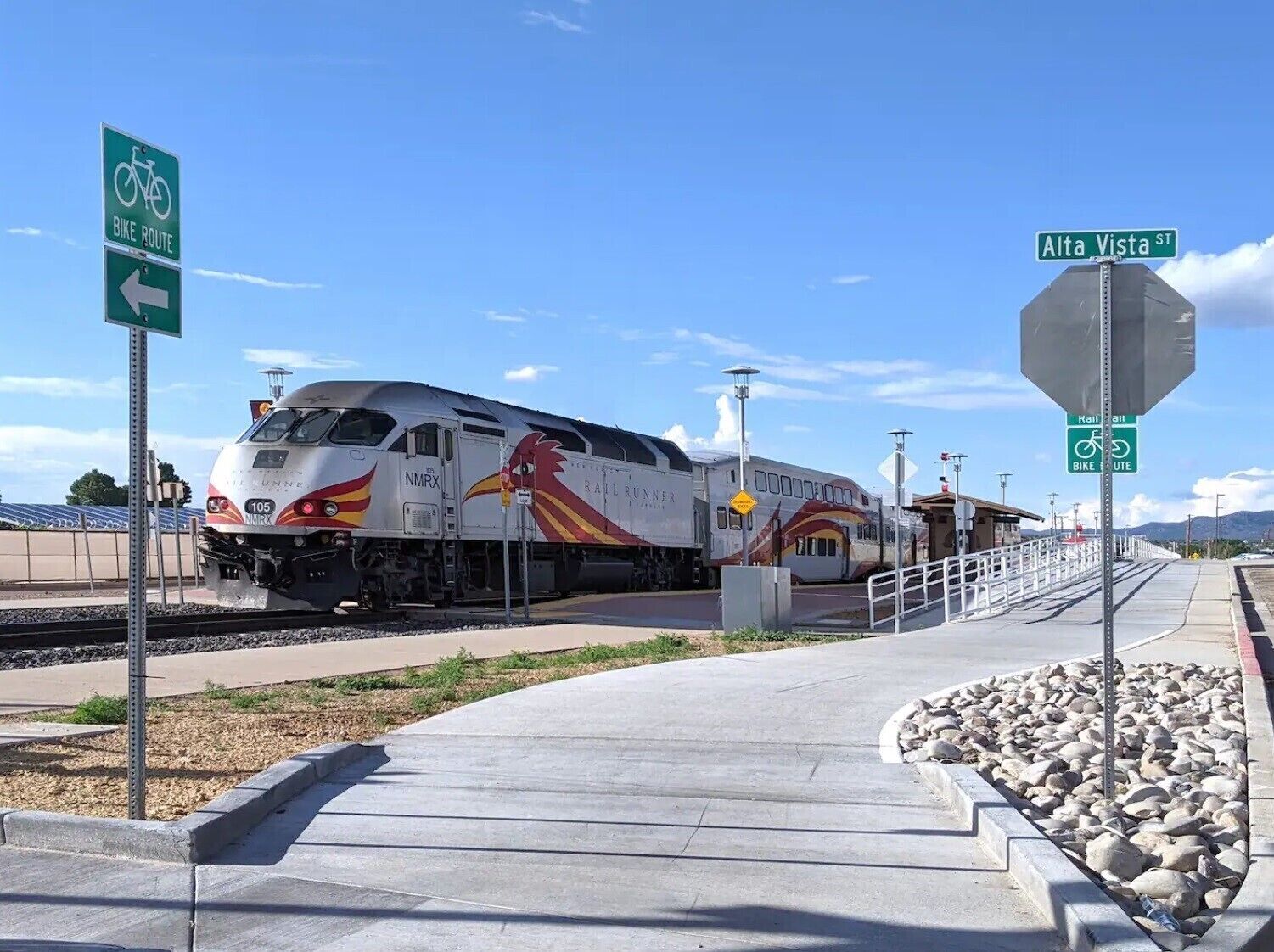 Un tren en una estación, con un indicador de ciclovía y una señal de calle para Alta Vista St.