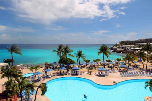 Una piscina al aire libre, sombrillas, tumbonas