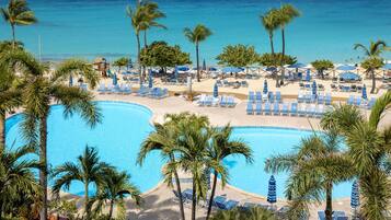 Ein Resort mit großem Pool, Liegestühlen und Palmen.