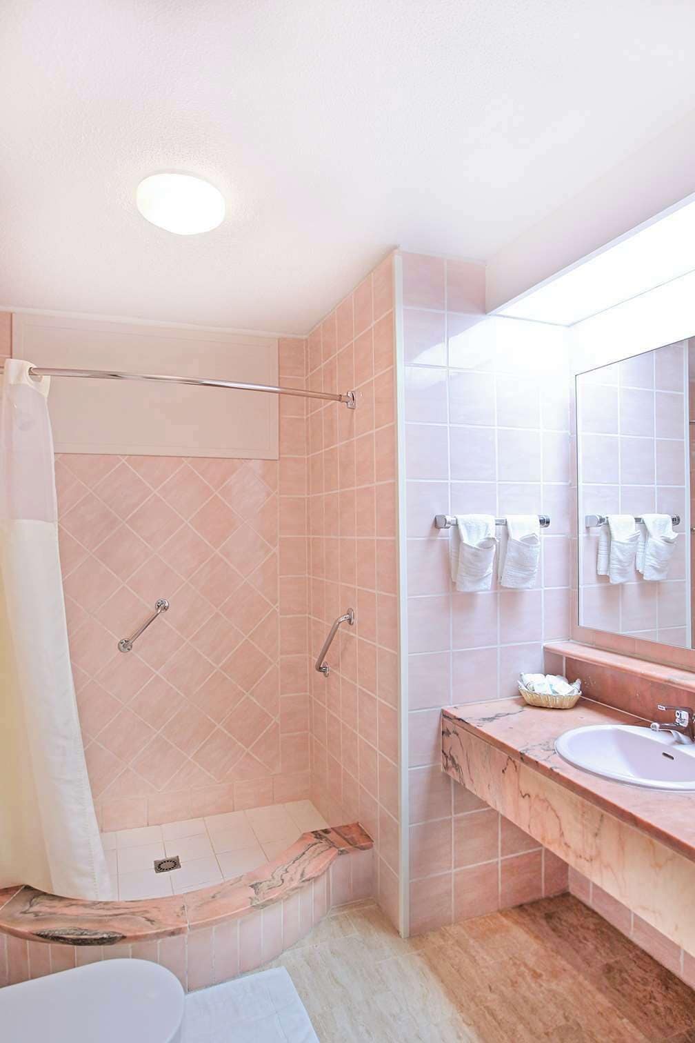 A modern bathroom with a shower, a vanity with a sink, and a large mirror.