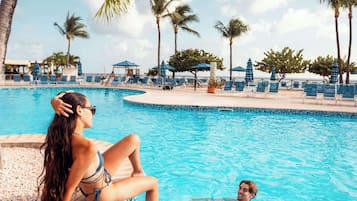 Een buitenzwembad, parasols bij het zwembad en ligstoelen