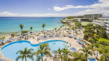 Een buitenzwembad, parasols voor strand/zwembad