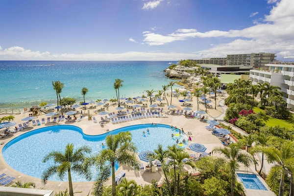 Een buitenzwembad, parasols bij het zwembad en ligstoelen
