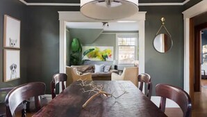A dining area with a dark wooden table, chairs, and a decorative branch centerpiece. - Walk to Space Needle Vintage View House with King Bed (Seattle)