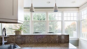 A kitchen with granite countertops, a stainless steel sink, and pendant lights. - Walk to Space Needle Vintage View House with King Bed (Seattle)