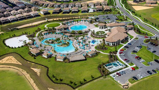 Ein Luftbild zeigt ein Resort mit mehreren Schwimmbecken, einem Golfplatz und einem Parkplatz.