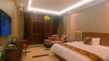 A hotel room with a bed, a desk, a television, and a window with curtains.