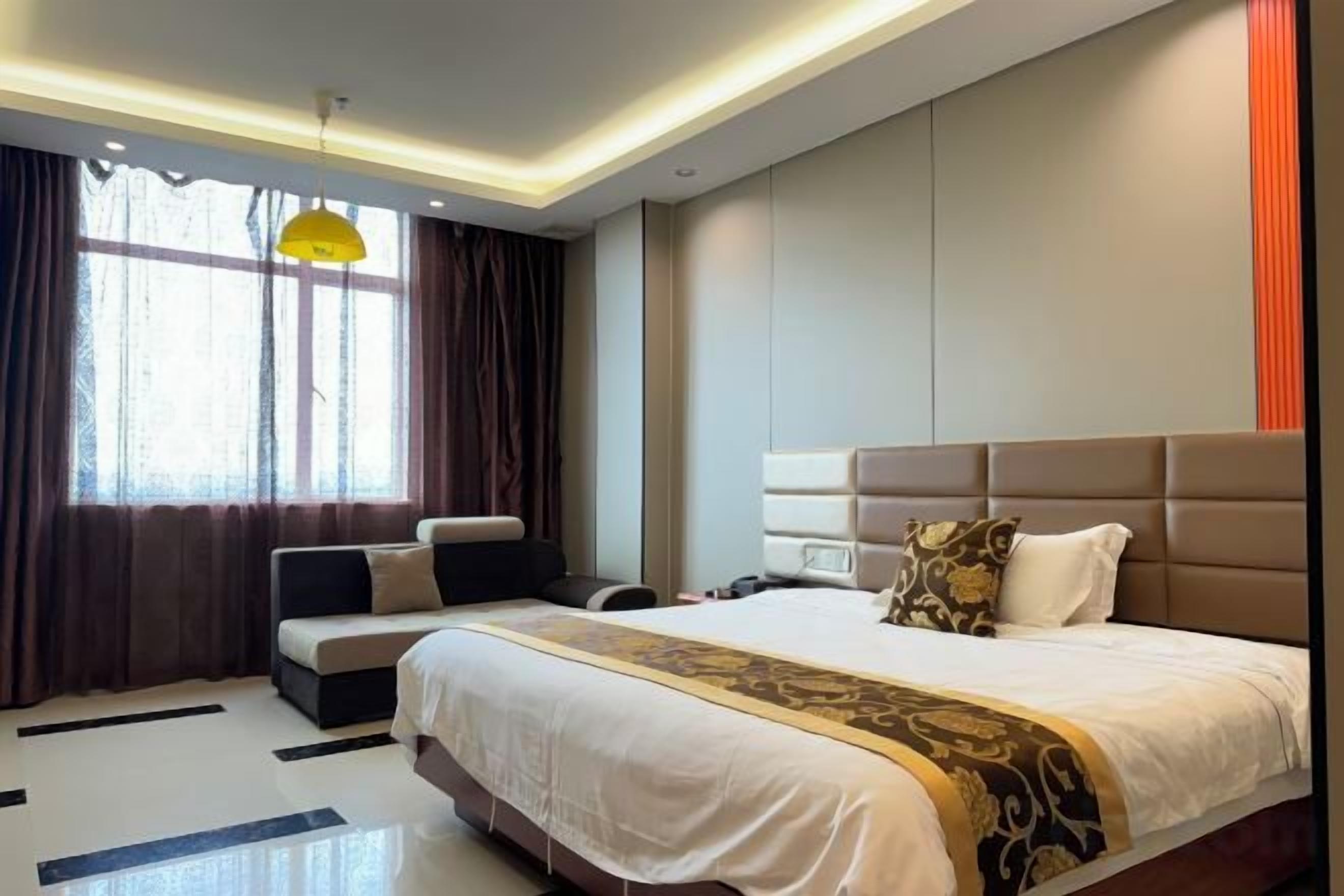 Una habitación de hotel moderna con una cama grande, un sofá, un escritorio y un ventanal con cortinas.