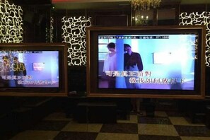 Two televisions mounted on a wall with decorative lighting. - Hengshan Hotel (Taishan)