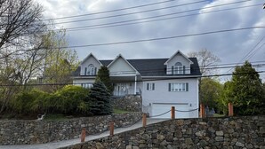 Une maison à deux étages avec un mur en pierre et un garage.