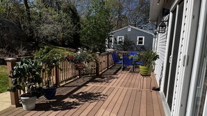 Une terrasse en bois agrémentée de plantes en pot et de mobilier d’extérieur.