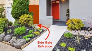 A modern building with a red door and a side gate entrance. - Garden Retreat | Firepit | 911Mbps | W/D| Smart TV (San Francisco)