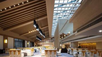 A spacious hall with tiered seating and a high ceiling with skylights.