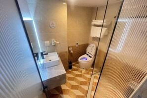 A bathroom with a checkered floor, a white sink, and a toilet with a blue light. - Fan She Fashion Hotel (Heyuan)