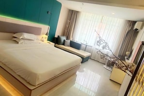 A modern hotel room with a large bed, a seating area, and a window with curtains. - Fan She Fashion Hotel (Heyuan)