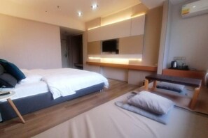 A modern hotel room with a large bed, bedside tables, a desk, and a flat-screen TV mounted on the wall. - Fan She Fashion Hotel (Heyuan)