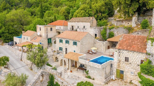 Un village de pierre à l’architecture traditionnelle, doté d’une piscine et relié au reste du monde par une route.