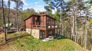 A two-story wooden cabin with a stone foundation, a balcony, and a stone fireplace. - "This cabin is absolutely beautiful and in a gorgeous and quiet area!" (Sevierville)