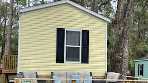 A yellow building with a sign indicating guest parking. - Rainbow River Bungalow D (Dunnellon)