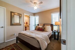 A bedroom with a bed, a ceiling fan, a nightstand, and a window with blinds. - Waterfront PK Lake Home with Private Boat Dock (Graford)