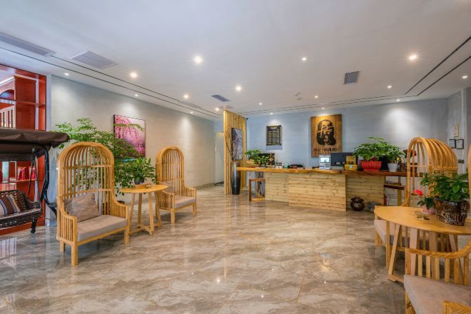 Un vestíbulo de hotel con mostrador de recepción, zona de estar y una escalera.