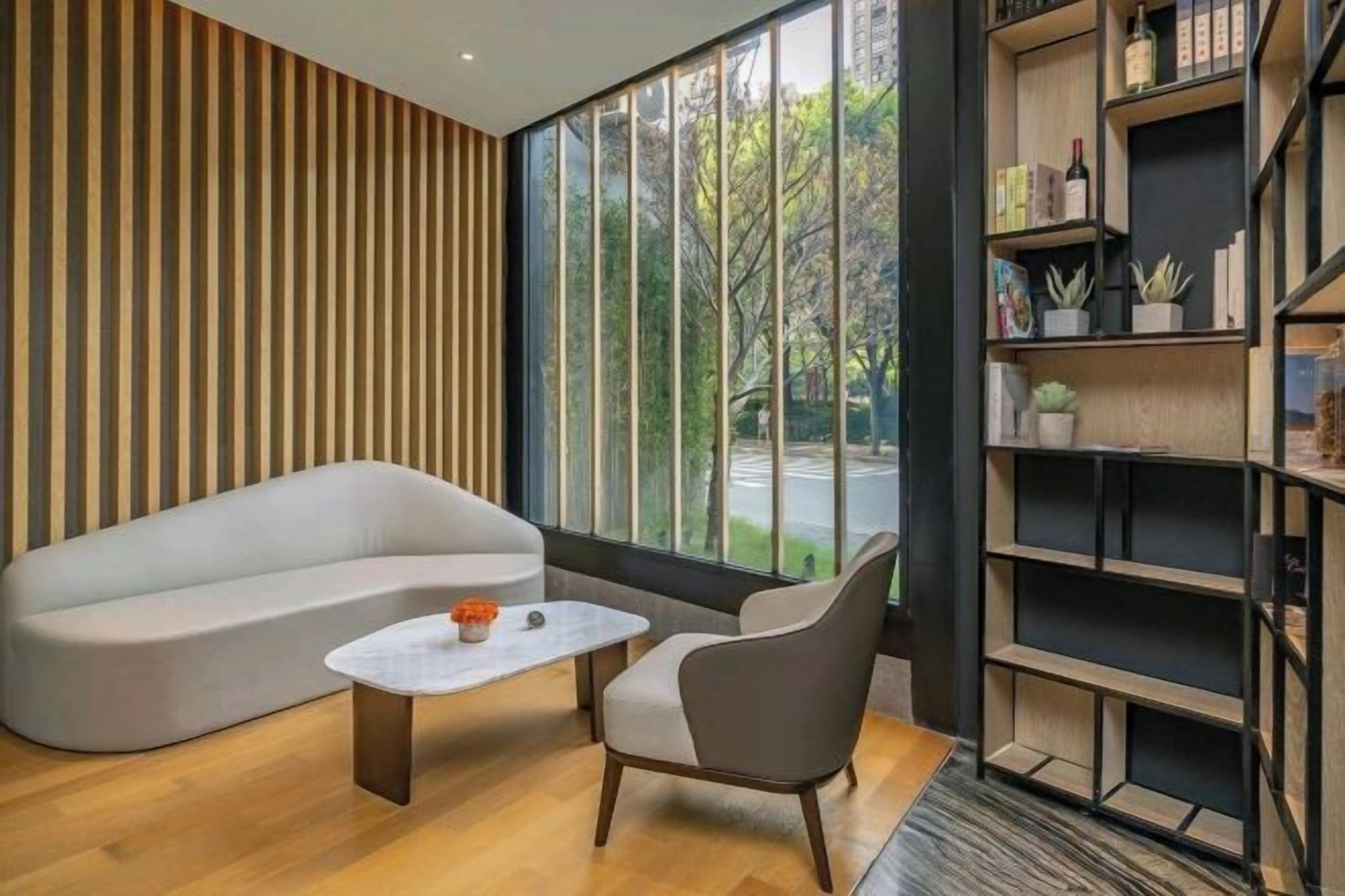 A modern living room with a sofa, a coffee table, and a bookshelf.